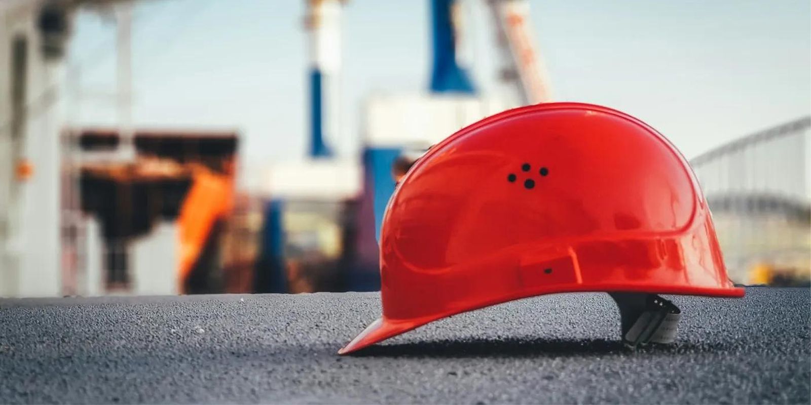 Casco de seguridad rojo sobre el asfalto